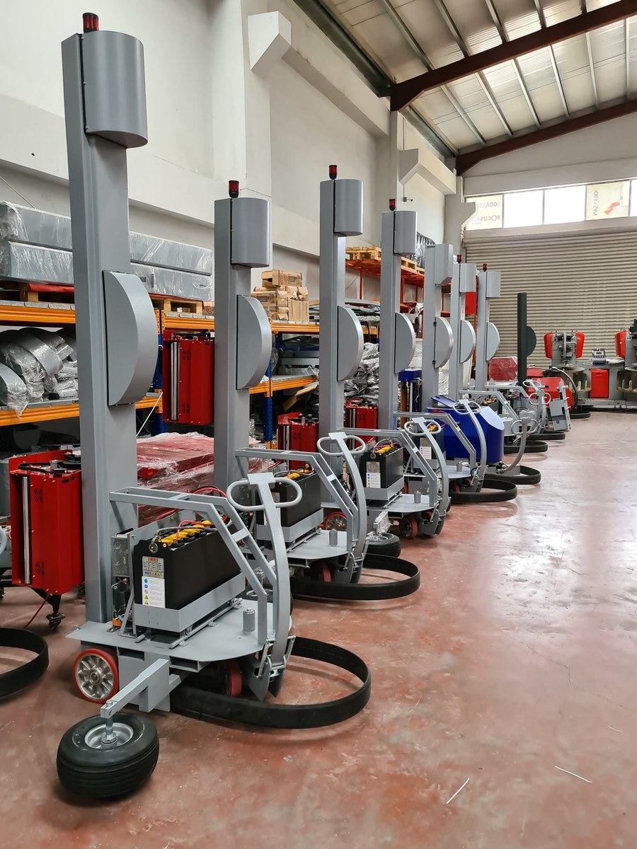 Fleet of mobile pallet wrapping machines lined up inside a warehouse